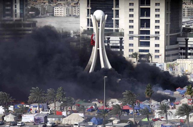 دخان اسود يتصاعد من ساحة دوار اللؤلؤ في المنامة بعد أن هاجمت مكافحة الشغب و الجيش المحتجين صباح أمس (أ.ف.ب)
