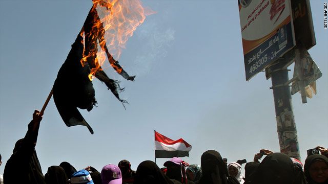 سيدة يمنية ترفع برقعا أحرقته احتجاجا على حكم صالح وسط صنعاء.