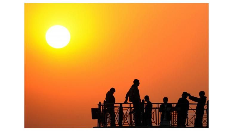 باكستانيون يرقبون غروب شمس آخر يوم في عام 2011 عند بحيرة سياحية