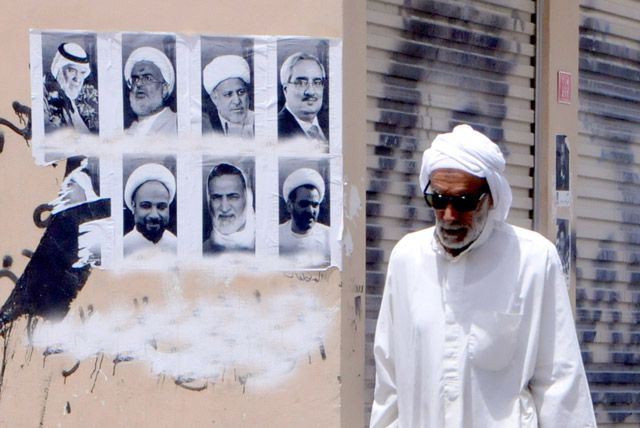 بحريني يمر بالقرب من صور للنشطاء عُلقت على أحد الجدران