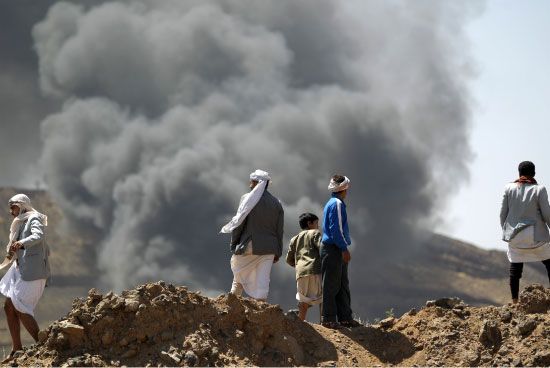يمنيون يشاهدون أعمدة الدخان بعد انفجار عرضي في مستودع للذخيرة-afp