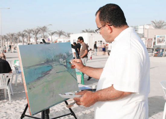 أحد الفنانين يرسم لوحته البيئية