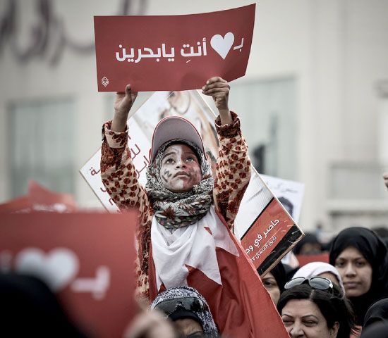 طفلة تحمل لافتة كُتب عليها «بقلبي أنتِ يا بحرين» خلال مسيرة «المعارضة» أمس - afp