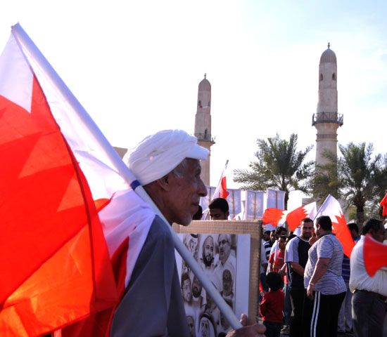 رجل بحريني يحمل علم البحرين قبالة مسجد الخميس خلال تظاهرة المعارضة أمس