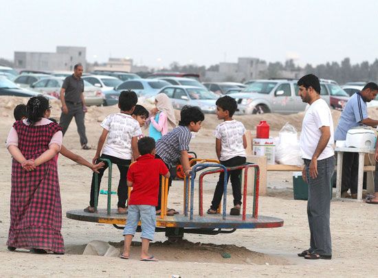 اللعب وعمل المجسمات الرملية على الساحل يستهويان الأطفال