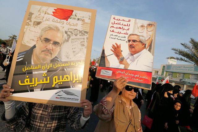 الناشطة فريدة غلام ترفع صورة زوجها المعتقل إبراهيم شريف خلال تظاهرة للمعارضة أمس - REUTERS
