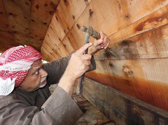 التيتون يباشر مهنته في صنع وإصلاح السفن الخشبية