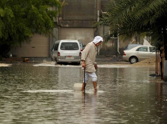 بحريني يعبر مياه الأمطار المتجمعة  -  (إرشيفية)