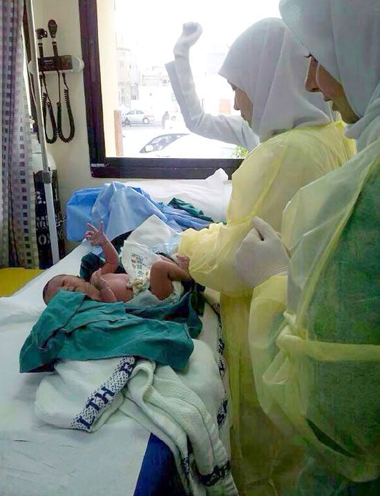 الممرضات يعاين المولودة