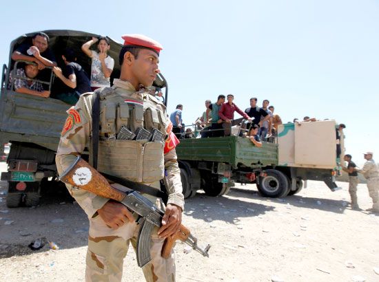 جندي عراقي يقف حارساً أمام عربات تابعة للجيش العراقي - reuters