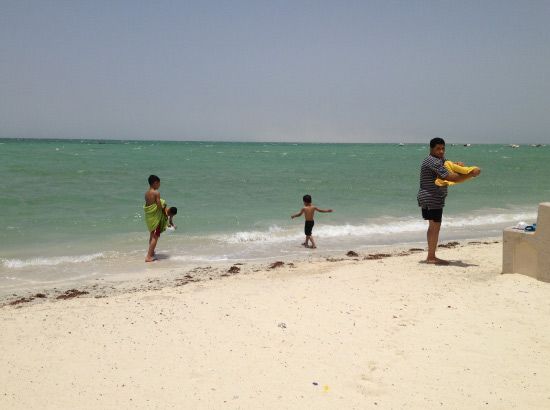 أب وأبناؤه يتهيأون للسباحة بساحل المالكية