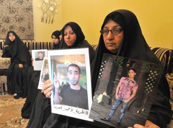 والدة أحد المحكومين تحمل صوراً له بُعيد صدور الحكم أمس