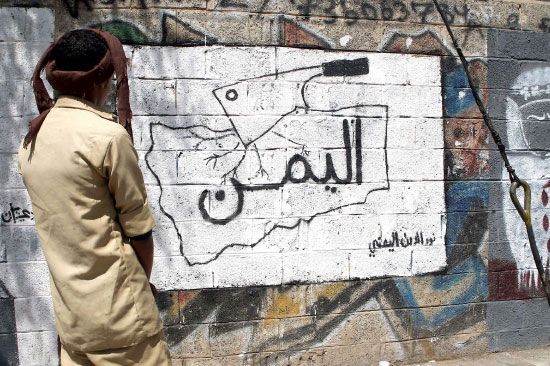يمني يعاين لوحة جدارية في أحد شوارع صنعاء - afp