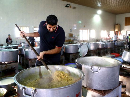 بحريني يباشر عملية الطبخ لتجهيز طلبات موسم عاشوراء