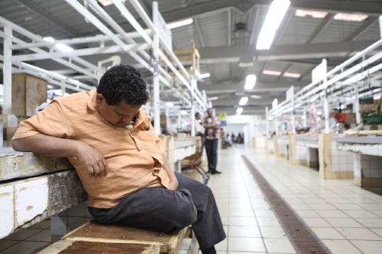 أحد العاملين في سوق اللحم يأخذ قسطاً من الرحة في ظل توقف العمل لغياب اللحوم