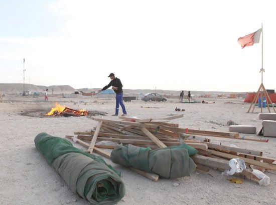 عبدالرحمن حسن يتخلص من مخلفات مخيمه عبر حرقها