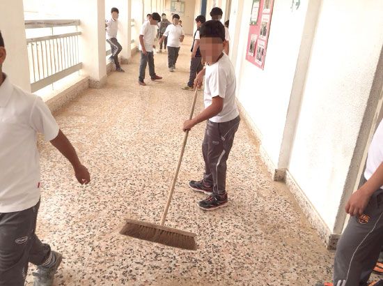طلاب ينظفون إحدى المدارس من الغبار