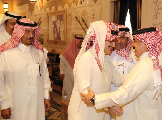 العاهل مصافحاً الأمير الوليد بن طلال خلال زيارته للسعودية