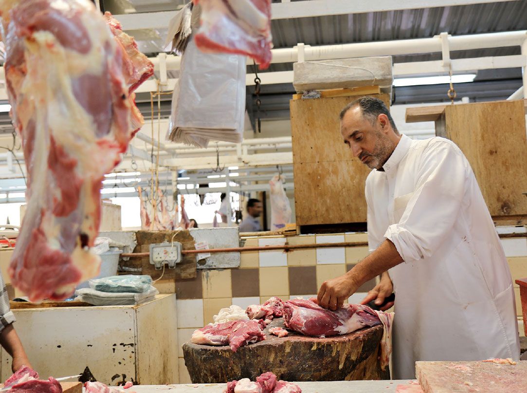 قصاب يتولى تشريح إحدى الذباح بسوق المنامة المركزي للحوم- تصوير محمد المخرق