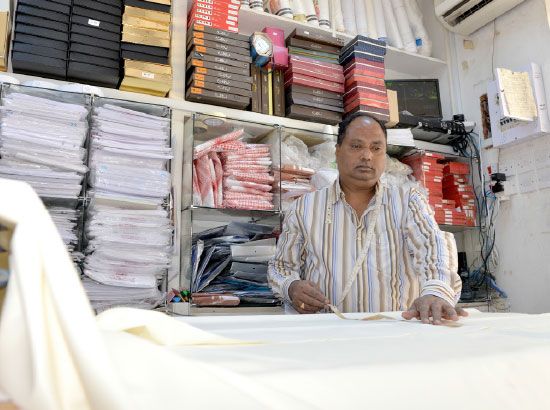 عمل دؤوب يقوم به العاملون في محلات الخياطة الرجالية لإنجاز أثواب العيد