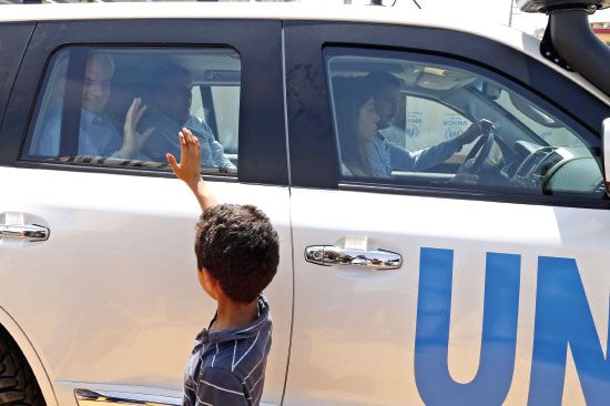 مدير العمليات الإنسانية في الأمم المتحدة ستيفن اوبراين يتبادل التحية مع طفل من اللاجئين السوريين - reuters