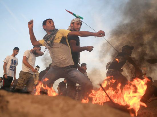 متظاهرون فلسطينيون يلقون الحجارة على الجنود الإسرائيليين خلال إحدى المواجهات - afp