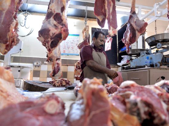 قصاب يعمل على تقطيع اللحوم في أحد المحلات 