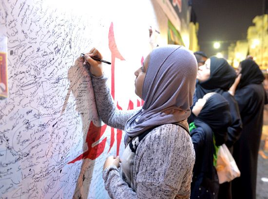 نساء يشاركن بعبارات وتواقيع في لوحة عن عاشوراء في المنامة