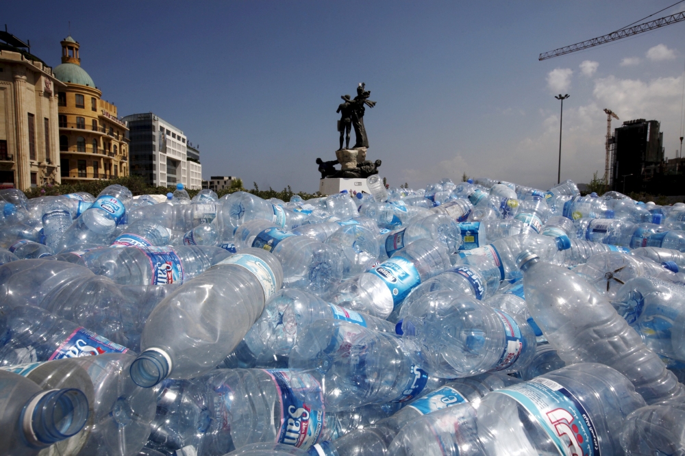 تجميع زجاجات المياه لإعادة تدويرها بالقرب من تمثال في ساحة الشهداء في بيروت (25 أغسطس 2015)
