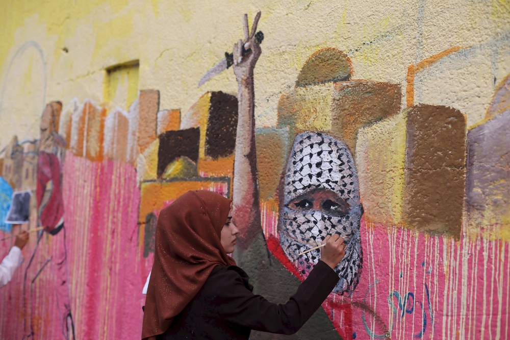 فلسطينية ترسم جدارية  لدعم الفلسطينيين في رفح في جنوب قطاع غزة (3 نوفمبر 2015)