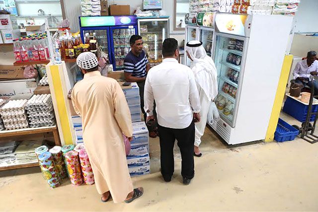 البائع حسين حيان مع زبائنه في سوق المحرق