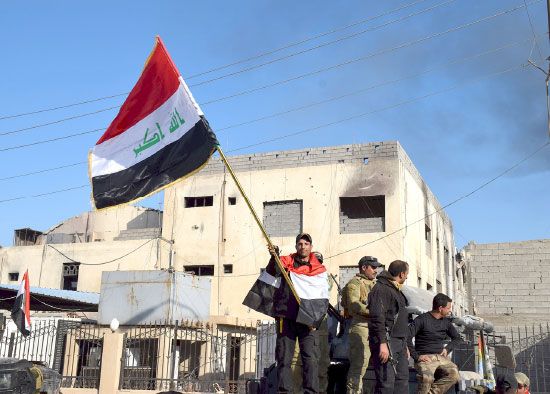 جنود عراقيون يرفعون العلم العراقي داخل المجمع الحكومي في وسط الرمادي - reuters