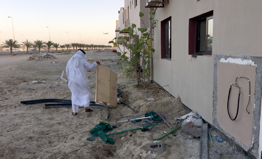 ﻿صاحب أحد بيوت قلالي الإسكانية يرفع بقايا صندوق أسطوانات الغاز بعد أن دمرته جرافات «الإسكان»