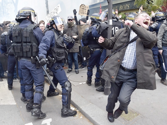 ﻿شرطي من مكافحة الشغب الفرنسية يضرب أحد المشاركين في مظاهرة ضد الإصلاحات العمالية التي اقترحتها الحكومة في باريس - afp