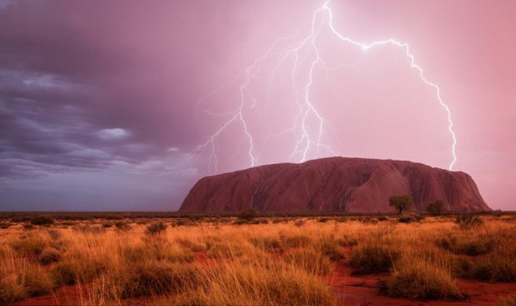 أولورو، أو ايرز روك، مضاءة من قبل العديد من ومضات البرق كما تتحرك عاصفة من خلال يولارا، الإقليم الشمالي، أستراليا