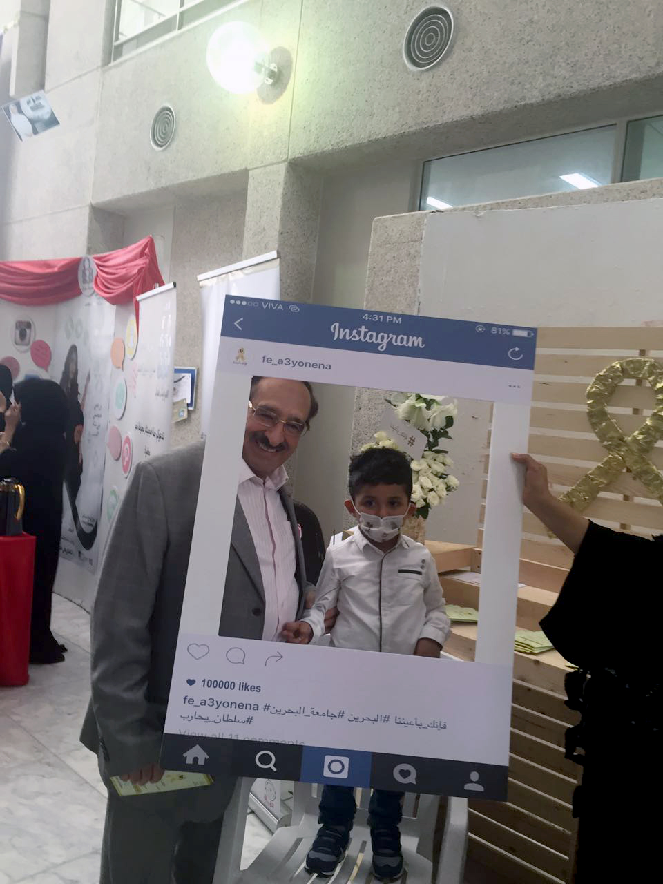 الشاعر علوي الهاشمي مع الطفل سلطان في الفعالية التي أقيمت بجامعة البحرين اليوم (الإثنين)