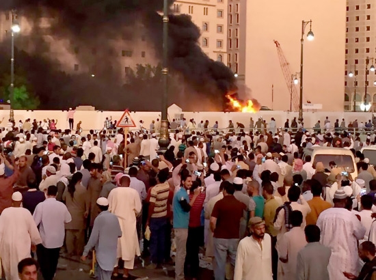 ﻿جمعٌ من المصلين يشاهدون الدخان بعد تفجير انتحاري قرب المسجد النبوي الشريف في المدينة المنورة - reuters