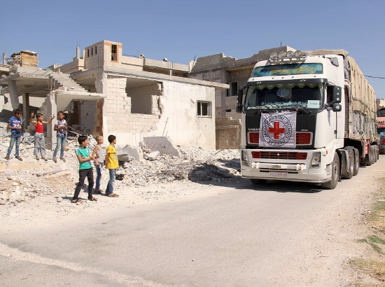 ﻿أطفال سوريون خلال مرور قافلة من ٤٨ شاحنة تابعة إلى اللجنة الدولية والهلال الأحمر السوري أثناء دخولها تير معلة على مشارف مدينة حمص - afp
