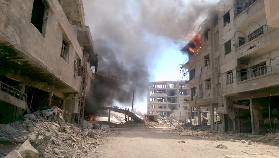 ﻿النيران تتصاعد من المباني إثر ضربات جوية في داريا السورية - afp