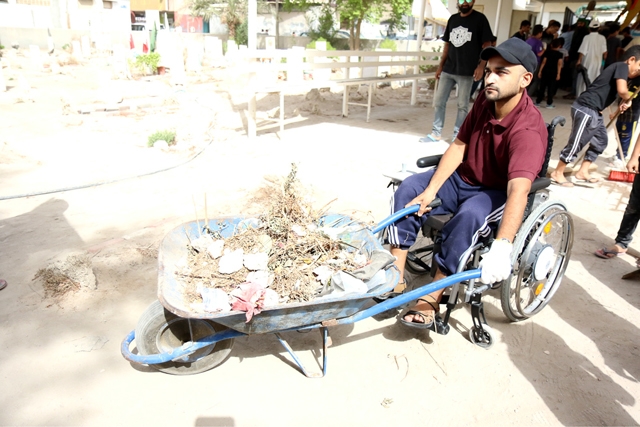 ﻿شخص من ذوي الاحتياجات الخاصة مشاركاً في حملة التنظيف