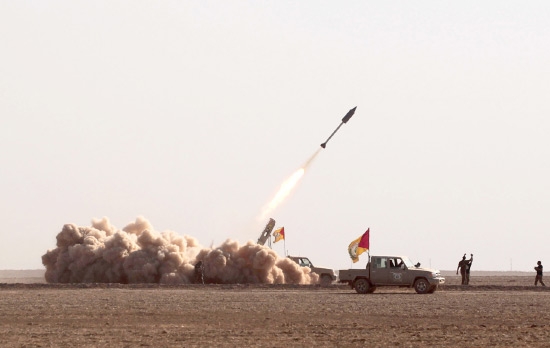 ﻿مقاتلون من الحشد الشعبي يطلقون صاروخاً تجاه «داعش» جنوب غرب الموصل - afp