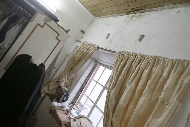﻿الأرملة البحرينية تشير إلى سقف منزلها المتهالك