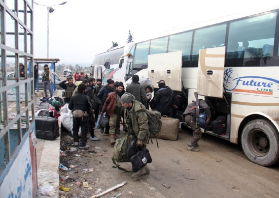 ﻿ مقاتلو المعارضة المسلحة أثناء خروجهم من حلب متوجهين إلى مناطق أخرى متفق عليها مسبقاً - afp