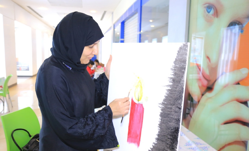 ﻿بحرينية ترسم في المعرض - تصوير أحمد ال حيدر