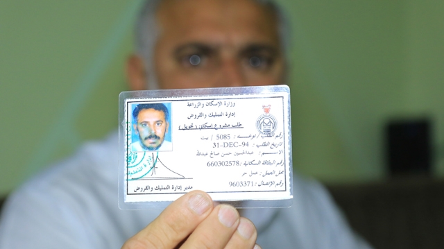 ﻿عبدالحسين يحمل بطاقة طلبه الإسكاني الذي يعود للعام 1994