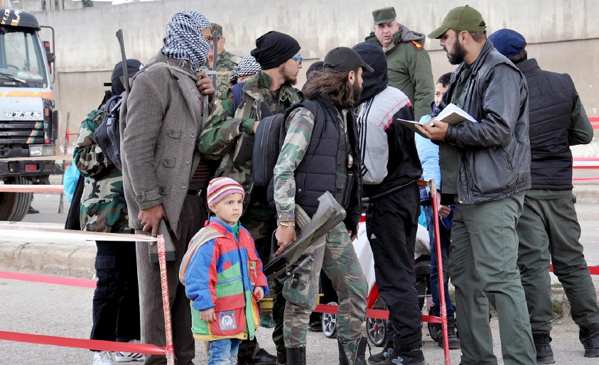 ﻿مسلحون وعوائلهم خلال إجلائهم من حي الوعر في حمص-EPA