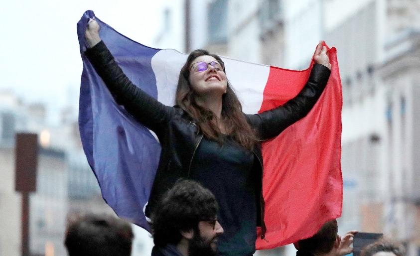 ﻿فرنسية مؤيدة لماكرون تحتفل بعد إعلان فوزه في باريس - REUTERS