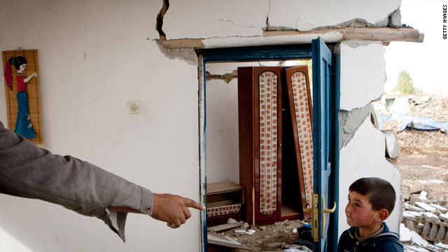 طفل تركي يقف داخل أحد المنازل المهدمة نتيجة الزلزال الذي ضرب شرقي البلاد الأحد.