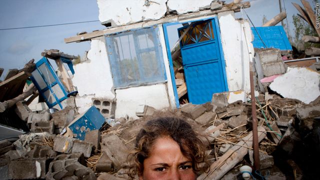 طفلة تركية تقف أمام أحد المنازل التي هدمت نتيجة الزلزال.