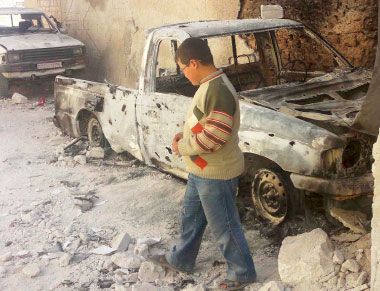 صبي ينظر في المنازل المتضررة بعد قصف عنيف من قبل القوات الحكومية  بالقرب من مدينة إدلب